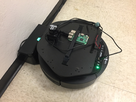 Kobuki mobile base on its charging station and with Hokuyo laser range finder and Raspberry Pi 3 Model B mounted